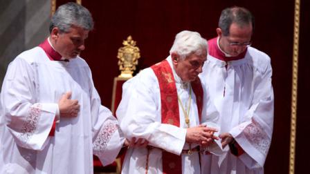 Pope Benedict XVI is sustained during the Good Friday Passion Mass, in St. Peters Basilica, at the Vatican, Friday, April 6, 2012. Pope Benedict XVI has begun a Good Friday service at the Vatican by kneeling in silent prayer. Benedict rested his folded hands on a red cushion near the central altar of St. Peters Basilica as he prayed during the solemn commemoration of Jesus death by crucifixion. Hours later, Benedict will go to Romes Colosseum to preside over the traditional Way of the Cross procession. (AP Photo/Riccardo De Luca)
