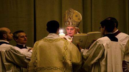 Pope Benedict XVI lights a white candle as he enters a hushed and darkened St. Peters Basilica, at the Vatican Saturday, April 7, 2012, to begin the Vaticans Easter vigil service. Except for the twinkle of camera flashes, the basilica was almost pitch-black as the thousands of faithful in pews awaited Benedicts arrival through the rear entrance Saturday night. Christians on Easter joyously mark their belief that Christ rose from the dead after his crucifixion. Praying at the start of the service, Benedict said Easter brings hope to the faithful. On Sunday morning, he will lead Easter Mass in St. Peters Square. (AP Photo/Vincenzo Pinto, POOL)