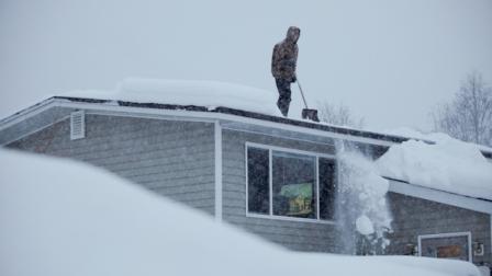 14-year-old Doug Hamrick shovels snow off of his familys roof Thursday, Jan.12, 2012, in Anchorage. (AP Photo/Loren Holmes)