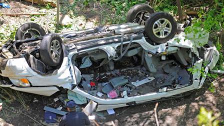 Police investigate the destroyed SUV that plunged over the Bronx River Parkway, Sunday April 29, 2012, in New York. Authorities say the out-of-control SUV plunged off a roadway near the Bronx Zoo, killing seven people, including three children. (AP Photo/ Louis Lanzano)