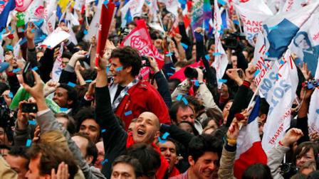 Supporters of Socialist Party candidate for the presidential election Francois Hollande react after the first results of the second round of French presidential elections outside Socialist Party campaign headquarters in Paris, France, Sunday, May 6, 2012. First results show that Hollande had won the election. (AP Photo/Francois Mori)