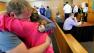 Daniel Bowley, left, hugs his sister after Aaron Deveau, 18, seated at right, was found guilty in Haverhill District Court in Haverhill, Mass., Wednesday, June 6, 2012, on charges of motor vehicle homicide while texting. Authorities said the then-17-year-old Deveau was texting when he crossed the center line of a Haverhill street on Feb. 20, 2011 and crashed into a vehicle driven by Daniels father, Donald Bowley, of Danville, N.H., who died 18 days later in the hospital. (AP Photo/Eagle Tribune, Tim Jean, Pool) 