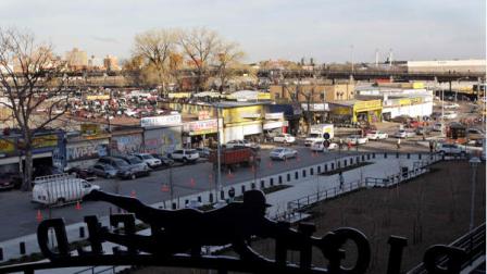 Pedestrians walk around auto shops in Willets Point near Citi Field before a baseball game between the New York Mets and the Milwaukee Brewers Friday, April 17, 2009, in the Queens borough of New York. (AP Photo/Frank Franklin II)