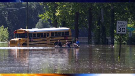 Residents paddle down flooded streets past a stranded school bus in Live Oak Fla., Wednesday, June 27, 2012. Dozens of homes and businesses were flooded by torrential rains from Tropical Storm Debby. (AP Photo/Dave Martin)