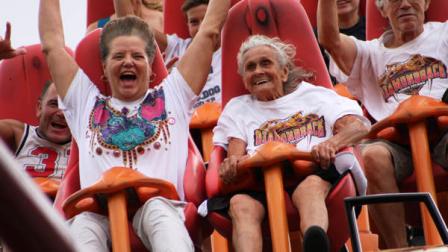 In this photo provided by Kings Island, Thelma Gratsch, center, celebrates her 90th birthday Friday, July 13, 2012, by riding her favorite roller coaster, Diamondback, at Kings Island amusement park in Mason, Ohio. Gratsch estimates she has ridden the tallest and fastest roller coaster at Kings Island more than 100 times since the ride opened in 2009. (AP Photo Kings Island, Don Helbig)