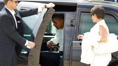 President Barack Obama removes his jacket as senior adviser Valerie Jarrett, right, prepares to enter the presidential limousine upon their arrival at Washington Dulles International Airport in Chantilly, Va., Saturday, July 14, 2012, for a campaign event in the vicinity. (AP Photo/Luis M. Alvarez)