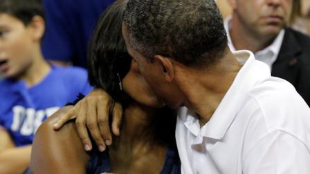 President Barack Obama, right, kisses first lady Michelle Obama for the Kiss Cam while attending the Olympic mens exhibition basketball game between Team USA and Brazil, Monday, July 16, 2012, in Washington. Team USA won 80-69. (AP Photo/Alex Brandon)
