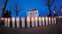 As night falls, candles sit iluminated along the...