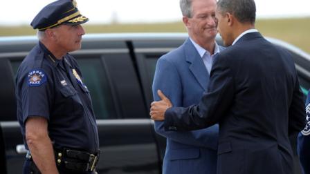 President Barack Obama greets Aurora (Colo.) Mayor Steve Hogan as Aurora Police Chief Daniel Oates, left, watches after Obama arrived at at Buckley Air Force Base, Colo., Sunday, July 22, 2012. (AP Photo/Susan Walsh)