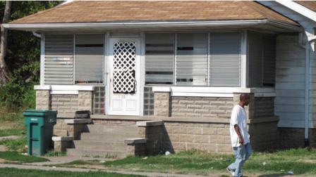 A man passes by a Washington Park, Ill., home Friday, Aug. 24, 2012, where a 19-year-old St. Louis woman claims she was held captive for more than three years before managing to escape on Monday, Aug. 20 and notify police. (AP Photo/Jim Suhr)