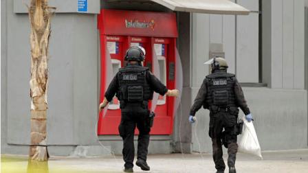 Los Angeles Police bomb squad members check for explosive devices outside a Bank of America branch in Los Angeles Wednesday, Sept. 5, 2012. (AP Photo/Damian Dovarganes)