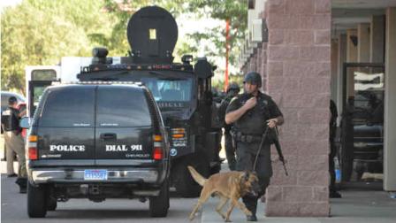 A Sioux Falls, S.D., SWAT team member walks a police dog out of a Cost Cutters hair salon, Tuesday, Sept. 11, 2012, after officers entered and found a gunman dead of an apparent self-inflicted gunshot wound. Police say the gunman kidnapped his two kids from a babysitter at gunpoint, shot an employee, Amanda Connors, to death in a car in the parking lot and then holed up inside the salon. (AP Photo/Dirk Lammers)