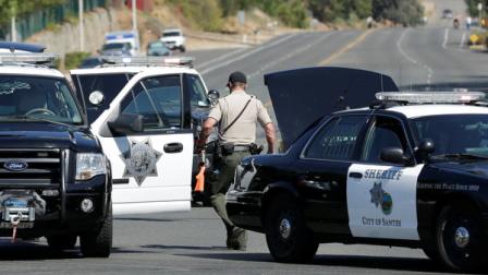 A police official carries a weapon in front of the Maplewood Apartments after a shooting in Lakeside, Calif., Tuesday, Sept. 25, 2012. The San Diego County sheriffs Capt. Duncan Fraser said two deputies and a suspect have been shot while the deputies were trying to contact a child abuse suspect at the suburban apartment complex. (AP Photo/Gregory Bull)