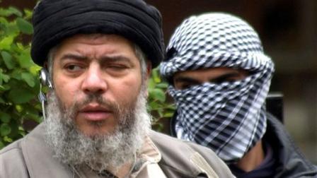 FILE - This Friday, April 30, 2004 file photo shows Muslim cleric Abu Hamza al-Masri, as he arrives with a masked bodyguard, right, to conduct Friday prayers in the street outside the closed Finsbury Park Mosque in London. A British court is expected to rule on whether extremist cleric Abu Hamza al-Masri is too ill to be extradited to the United States to face terror charges. Londons High Court is set to decide Friday Oct. 5, 2012 whether al-Masri and other terror suspects can be sent to the U.S. to face charges that include helping set up a terrorist training camp in rural Oregon. (AP Photo/Max Nash, File)