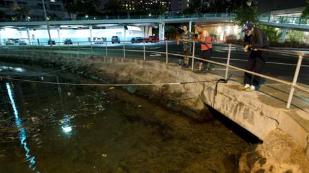 Visitors and Oahu residents watch the ocean water surge into the Ala Wai Harbor carrying various debris during a tsunami Saturday, Oct. 27, 2012, in Honolulu. The water dropped about a foot then came up a foot in about 30 seconds. The first waves of a tsunami hitting Hawaii on Saturday night hit shore smaller than expected roughly three hours after officials ordered evacuations of all coastal areas threatened after a powerful earthquake off the coast of Canada. Gerard Fryer, a geologist tracking the tsunami for the Pacific Tsunami Warning Center, said the largest wave in the first 45 minutes of the tsunami was measured at 5 feet in Maui. State and local officials warned residents and tourists not to go back to inundation zones until an all-clear is given.