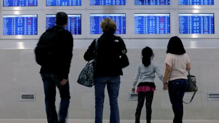 Travelers on Delta Airlines look at a departure screen Monday, Oct. 29, 2012, in Detroit. Dozens of departing flights have been canceled at Detroit Metropolitan Wayne County Hurricane Sandy continued on its path Monday, as the storm forced the shutdown of mass transit, schools and financial markets, sending coastal residents fleeing, and threatening a dangerous mix of high winds and soaking rain. (AP Photo/Charlie Riedel)