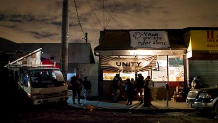 In this Thursday, Nov. 8, 2012 photo, at YANA (You are Never Alone), an outreach center that is currently housing Occupy Sandy, a volunteer aid organization in the Rockaway Park neighborhood of the Queens borough of New York, volunteers and those seeking assistance stand outside. Along with other groups, Occupy Sandy has sprung up in an effort to bring goods and services to people left in need in the wake of Superstorm Sandy. (AP Photo/Craig Ruttle)