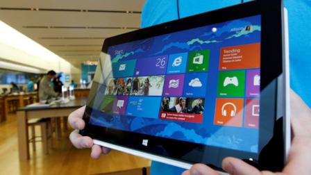A Microsoft store product advisor displays the new Surface table computer as customers enter the store as it opens Friday, Oct. 26, 2012 in Seattle. (AP Photo/Elaine Thompson)