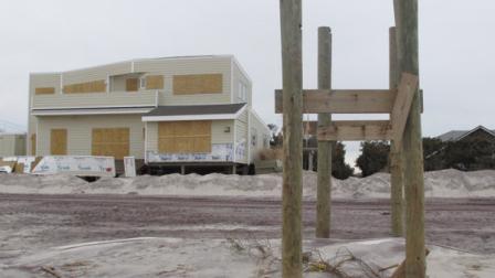 Pilings that once held a walkway over dunes leading to the beach are all that remain outside a boarded up home on Friday, Nov. 16, 2012, in Ocean Beach, N.Y. The Fire Island community was damaged in Superstorm Sandy.(AP Photo/Frank Eltman)