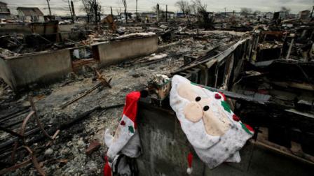 FILE - In this Nov. 13, 2012 file photo, Christmas decorations from the charred remains of a home, are shown in the Breezy Point section New Yorks Queens borough. More than 50 homes were lost in a fire that swept through the oceanside community during Superstorm Sandy. Some residents of New York Citys storm-battered Breezy Point neighborhood say thieves looted their damaged houses over Thanksgiving. (AP Photo/Mark Lennihan)