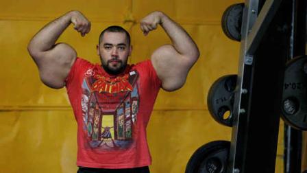 In this photo taken, Friday, Nov. 16, 2012, Egyptian Body builder Moustafa Ismail poses during his daily workout at World Gym in Milford, Mass. Ismail has been given the title of worlds biggest arms, biceps and triceps, by the Guinness Book of World Records. (AP Photo/Stephan Savoia)