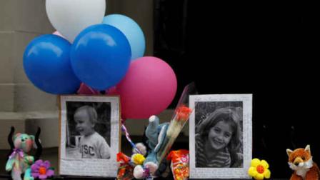 FILE - In this Oct. 27, 2012 file photo, Photographs of the two children allegedly stabbed by their nanny are displayed alongside balloons and stuffed animals at memorial outside the apartment building were they lived in New York. (AP Photo/Mary Altaffer)