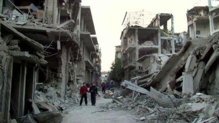 Syrian citizens walk in a destroyed street that was attacked on Wednesday by Syrian forces warplanes, at Abu al-Hol street in Homs province, Syria, Thursday Nov. 29, 2012. (AP Photo/Homs City Union of The Syrian Revolution)