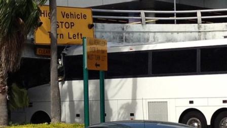 A bus is lodged into an overpass at the Miami International Airport on Saturday, Dec. 1, 2012. The vehicle was carrying over 30 people when it crashed into the structure. Authorities say buses typically are routed through the departures area, which has a higher clearance. (AP Photo/Suzette Laboy)