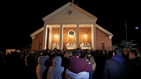 As hundreds stand outside St. Rose of Lima Roman Catholic Church, which was filled to capacity, a couple embrace during a healing service held in for victims of an elementary school shooting in Newtown, Conn., Friday, Dec. 14, 2012. A gunman opened fire at Sandy Hook Elementary School in Newtown, killing 26 people, including 20 children. (AP Photo/Charles Krupa)