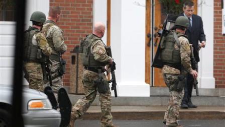 A Conn. State Police tactical team searches the area around St. Rose of Lima Catholic Church after a bomb scare during services Sunday, Dec. 16, 2012 in Newtown, Conn. A gunman opened fire on Friday at Sandy Hook Elementary School in the town, killing 26 people, including 20 children before killing himself. (AP Photo/Charles Krupa)