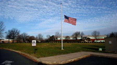 The American flag flies at half-staff outside the Newtown, Pa., post office Sunday, Dec. 23, 2012, in honor of the victims of last weeks shootings in Newtown Conn. (AP Photo/Mel Evans)