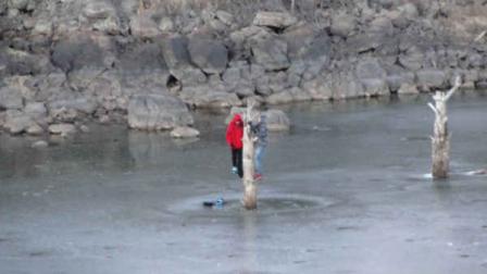 In a Wednesday, Jan 2, 2013 photo provided by the Lakeside Fire District, two teenagers hang on to a dead tree while trapped after the ice ion the lake started to crack, in Show Low, Ariz. (AP Photo/Lakeside Fire District, Kirk Webb)