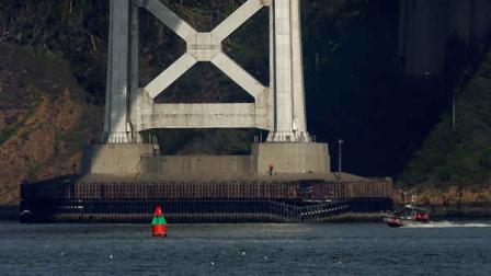 A worker inspects damage to the bottom of a tower on the San Francisco-Oakland Bay Bridge in San Francisco, Monday, Jan. 7, 2013. The empty oil tanker ship, Overseas Reymar, struck the San Francisco-Oakland Bay Bridge on Monday, but there were no reports of leaking oil and the bridge remained open to traffic, officials said. (AP Photo/Jeff Chiu)