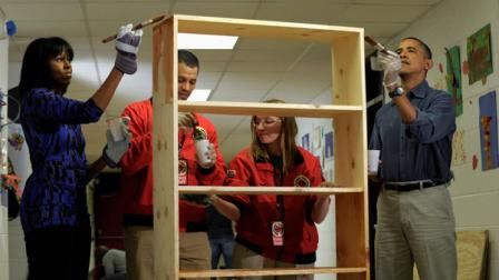 President Barack Obama and first lady Michelle Obama stain a bookshelf at Burrville Elementary School in Washington, Saturday, Jan. 19, 2013, as the the first family participated in a community service project for the National Day of Service, part of the 57th Presidential Inauguration. (AP Photo/Susan Walsh)