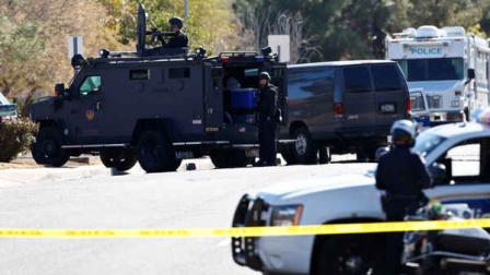 Members of the Phoenix Police Department, including the SWAT team, back left, surround the home of a suspected gunman who opened fire at a Phoenixoffice building, wounding three people, one of them critically, and setting off a manhunt that led police to surround his house for several hours before they discovered he wasnt there, Wednesday, Jan. 30, 2013, in Phoenix. Authorities believe there was only one shooter, but have not identified him or a possible motive for the shooting. They dont believe the midmorning shooting at the complex was a random act. (AP Photo/Ross D. Franklin)