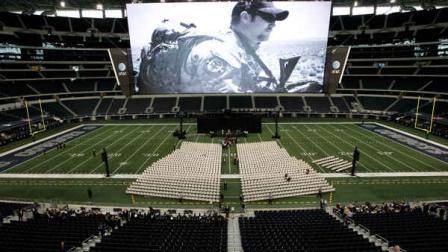 A photo of Christopher Kyle is displayed on the large screen before the start of a memorial service for the former Navy SEAL at Cowboys Stadium, Monday, Feb. 11, 2013, in Arlington, Texas. Thousands are expected to attend the public memorial service for Kyle, the former Navy SEAL sniper who was shot to death at a Texas shooting range. (AP Photo/Brandon Wade)