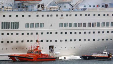 An orange rescue boat docks by a capsized lifeboat from the British-operated cruiseship Thomson Majesty in Santa Cruz port of the Canary Island of La Palma, Spain, Sunday Feb. 10, 2013. (AP Photo/Manuel Gonzalez)