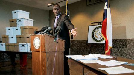 Dallas County District Attorney Craig Watkins addresses members of the media as he presents some historical documents and other memorabilia, in boxes to left and on table to right, connected to the assassination of President John F. Kennedy during a press conference in Dallas, Monday, Feb. 18, 2008. (AP Photo/Tony Gutierrez)