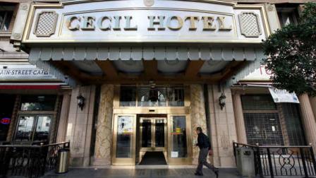 A visitor arrives at the hotel Cecil on Wednesday Feb. 20,2013 where police say the body of a woman was found wedged in one of the water tanks on the roof was that of a missing Canadian guest. Investigators used body markings to identify 21-year-old Elisa Lam, police spokeswoman Officer Diana Figueroa said late Tuesday. A maintenance worker at the Cecil Hotel found the body earlier in the day after guests complained of low water pressure. (AP Photo/Nick Ut)