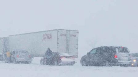 Drivers get out of their vehicles after a ramp is blocked by truck stuck in snow along I-35 in the Kansas City suburb of Overland Park. (AP Photo/Orlin Wagner)