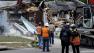 Demolition experts watch as the home of Jeff Bush, 37, is destroyed Sunday, March 3, 2013, after a sinkhole opened up underneath it late Thursday evening swallowing Bush, 37, in Seffner, Fla. The 20-foot-wide opening of the sinkhole was almost covered by the house, and rescuers said there were no signs of life since the hole opened Thursday night. (AP Photo/Chris OMeara)  