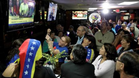 A crowd gathers at the Arepazo 2 restaurant in Doral, Fla., Tuesday, March 5, 2013, after hearing the news of Venezuelan president Hugo Chavezs death. (AP Photo/Luis M. Alvarez)