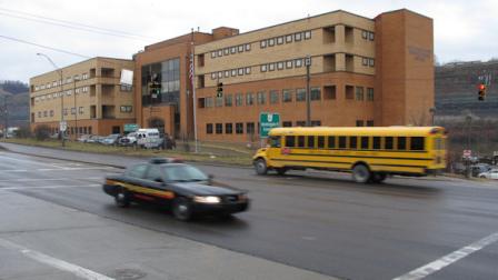 A sheriffs cruiser and a school bus cross paths in front of the Jefferson County Justice Center on Wednesday, Feb. 27, 2013 in Steubenville, Ohio. A court official briefing reporters ahead of two high school football players rape trial on March 13 says at least 40 witnesses could testify. (AP Photo/Andrew Welsh-Huggins)