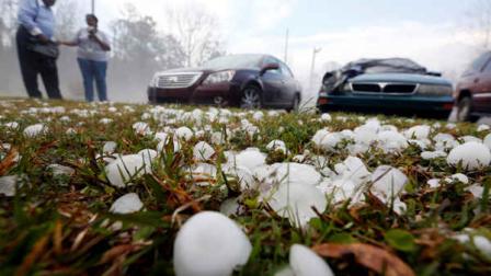 Golfball sized hail litter the ground by Andrew Stamps and his wife Valorie as they prepare to cover their shattered rear window of her 2009 Toyota Avalon in Pearl, Miss., Monday, March 18, 2013, following a hailstorm that hit communities throughout central Mississippi.