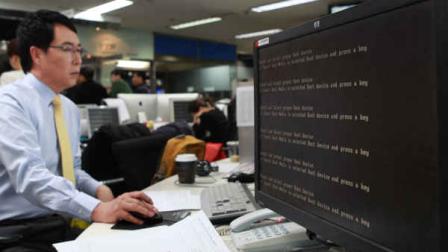 An employee works near a computer screen with error message at the newsroom of the all-news cable channel YTN as the broadcasters computer network was paralyzed in Seoul, South Korea, Wednesday, March 20, 2013. Computer networks at major South Korean banks and top TV broadcasters crashed en masse Wednesday, paralyzing bank machines across the country and prompting speculation of a cyberattack by North Korea. (AP Photo/Yonhap)