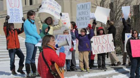 Kris Kitko leads chants of protest at an abortion-rights rally at the state Capitol in Bismarck, N.D., on Monday, March 25, 2013. More than 300 demonstrators attended the rally protesting a package of measures that would give the state the toughest abortion restrictions in the nation. (AP Photo/James MacPherson)