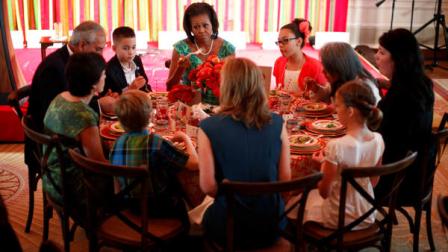 FILE - In this Aug. 20, 2012 file photo, First lady Michelle Obama sits with Michael Prados, left, from Louisiana, and Ilianna Gonzales-Evans, right, from Washington, and others, during the first Kids State Dinner, in the East Room of the White House in Washington. Children from across the nation will rub elbows with Michelle Obama and dine off fine china in the East Room of the White House this summer as part of a contest to promote healthy eating. The first lady is asking children ages 8 to 12 and their parents to create nutritious lunch recipes that represent each of the food groups for The Healthy Lunchtime Challenge. (AP Photo/Pablo Martinez Monsivais, File)