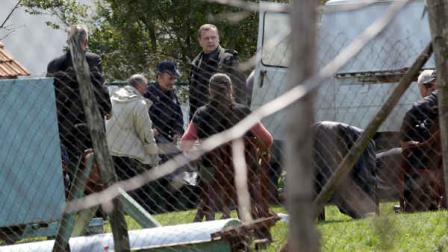 Police officers carry a body in village of Velika Ivanca, Serbia, Tuesday, April 9, 2013. A 60-year-old man gunned down 13 people, including a baby, in a house-to-house rampage in the quiet village on Tuesday before trying to kill himself and his wife, police and hospital officials said. (AP Photo/Darko Vojinovic)