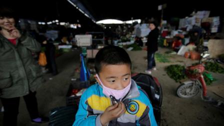 In this April 9, 2013 photo, a child wears a mask near the closed poultry section at the Huhuai agricultural market where the H7N9 bird flu was detected by authority in Shanghai, China. After a new and lethal strain of bird flu emerged in Shanghai two weeks ago, the government of Chinas bustling financial capital responded with live updates on a Twitter-like microblog. Its a starkly different approach than a decade ago, when Chinese officials silenced reporting as a deadly pneumonia later known as SARS killed dozens in the south. (AP Photo/Eugene Hoshiko)