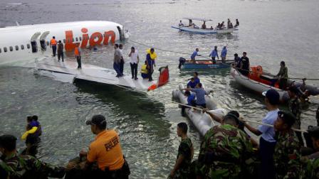 This photo released by Indonesias National Rescue Team shows rescuers at the crash site of a Lion Air plane in Bali, Indonesia on Saturday, April 13, 2013. The plane carrying more than 100 passengers and crew overshot a runway on the Indonesian resort island of Bali on Saturday and crashed into the sea, injuring nearly two dozen people, officials said. (AP Photo/National Rescue Team)